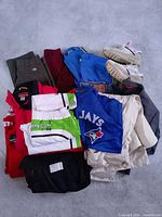 Pile of assorted clothing and Nike sneakers on floor