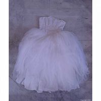 Full view of strapless white ball gown wedding dress laid flat showing beaded bodice and fluffy skirt