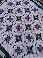 Full view of quilt showing overall eight-pointed star patchwork and border