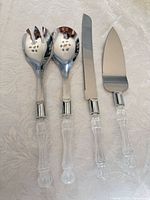 Full view of all four utensils showing stainless heads and clear handles