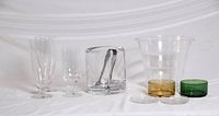 All items lined up: heavy glass ice bucket with tongs, plastic ice bucket, glasses, colored dishes and coasters