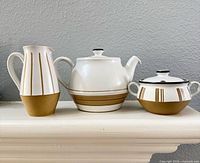 Creamer, teapot with lid, sugar bowl with lid showing pattern and color