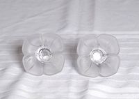 Top view of two crystal flower candle holders showing frosted petal design and central candle sockets