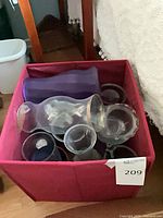 pink fabric cube containing glass vases and bowls