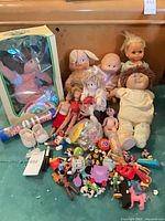 Group shot showing boxed Cabbage Patch doll, loose dolls, accessories, mini toys