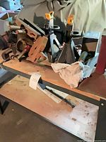 Workbench top shelf holding black jack stands, vise, drill, rag