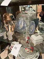 Overall lot showing glass domes, jasperware plate, figurine, trinket box, teacup, plate and napkins