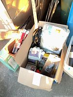 Overview of two boxes containing assorted household tools and items