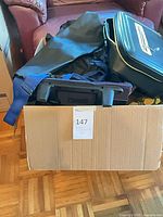 Box containing mixed bags and hard travel case