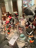 Overall view showing Disney figurines, plush bears, kokeshi dolls, glass bells, heart frame, porcelain items