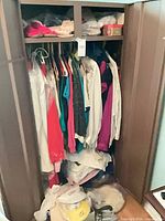 Wardrobe with hanging garments, visors and hat at bottom