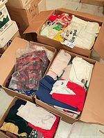 overview of three boxes filled with folded baby and toddler clothes
