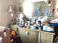 Front view of blond wood dresser showing curved central drawers and side drawers