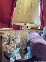 Entire lamp with shade and floral planter on table