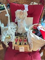 Group shot showing angel topper, wicker reindeer, boxed nutcrackers, stocking, tote of ornaments