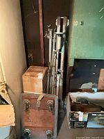 Overall view of metal stands, boxed grinder, dolly and boxed power tool