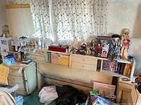 Bookcase headboard under window with shelves and drawers