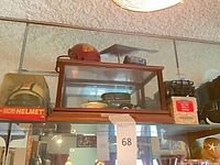 Full view of die-cast Ford Model A inside wood-frame glass case on shelf