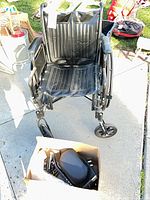 Front view of black Drive wheelchair with footrests in box