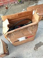 Closed cardboard shipping box, amplifier parts visible