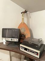 Turntable, television, oud displayed on shelf
