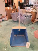 Full view of blue lobby dustpan with long handle