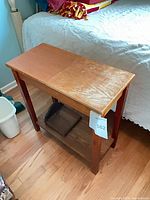 Front perspective of light oak veneer end table with lower shelf