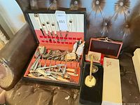 Open flatware case with knives, mixed cutlery, desk pen set, dominoes box, figurine, white box