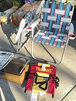 Overall view showing two lawn chairs, stadium seat, footstool and surrounding items