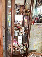Full curio cabinet view showing quantity and arrangement of assorted figurines