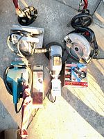 All tools laid out: two circular saws, angle grinder, belt sander, boxed rotary sander