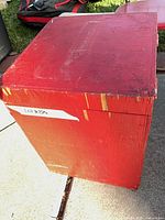 Red wooden storage cube/table showing chipped paint and wear