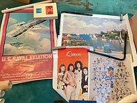 Group of four large posters laid out: Queen, Dodgers, U.S. Naval Aviation, nautical harbor scene