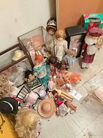 Group of dolls, display cases, boxed doll and accessories on floor