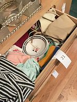 Open drawer showing bowl, garments, textiles