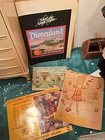 Group view of four posters/prints including Disneyland, USC schedule, Tipsy Trojan and landscape print