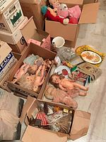Boxes of assorted dolls, plush toys, ceramic pieces, accessories