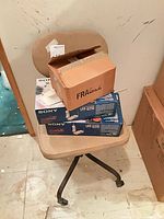 Chair with two boxed Sony SPP-Q210 phones and cardboard box on seat