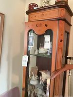 Full view of medium brown wood curio cabinet with glass door and shelves