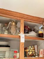 Cabinet overview showing carafes, bowls, plates, accessories