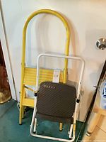 Overall view of yellow ladder and white Cosco stool