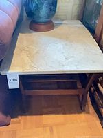 Front view of marble top end table showing full structure