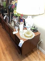 Angled side view showing top surface, lamp and photos placed on cabinet