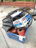 Overall view of crate containing boxed air filters, belts, inner tubes, hoses and exhaust tip