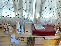 Shelf with red Brighton box, picture frame, mirror, vases and small plush toys