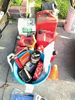 Overview showing gas cans, boxed work light, bucket of hardware, cones