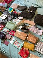Bed overview showing majority of handbags, pouches and wristlets