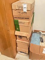 stacked cardboard boxes marked yarn beside open box with blue packaged sheet