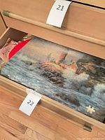 Drawer showing lighthouse puzzle board and surrounding textiles