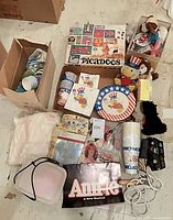 overview of lot showing partyware stacks, Picadoos box, Annie items, plush toys, toy camera, container
